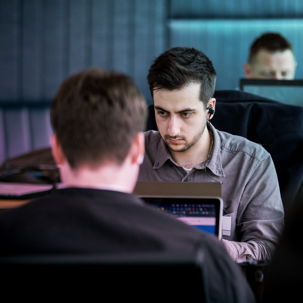 a man stares intently at his work, he is wearing headphones