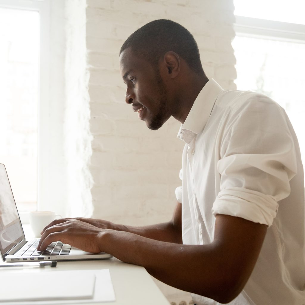 a man working on a laptop with his sleeves rolled up