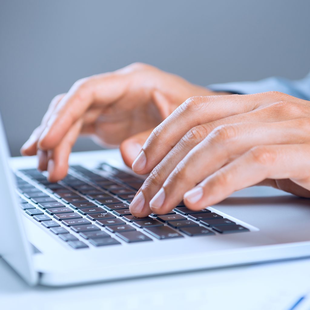 two hands typing on a keyboard