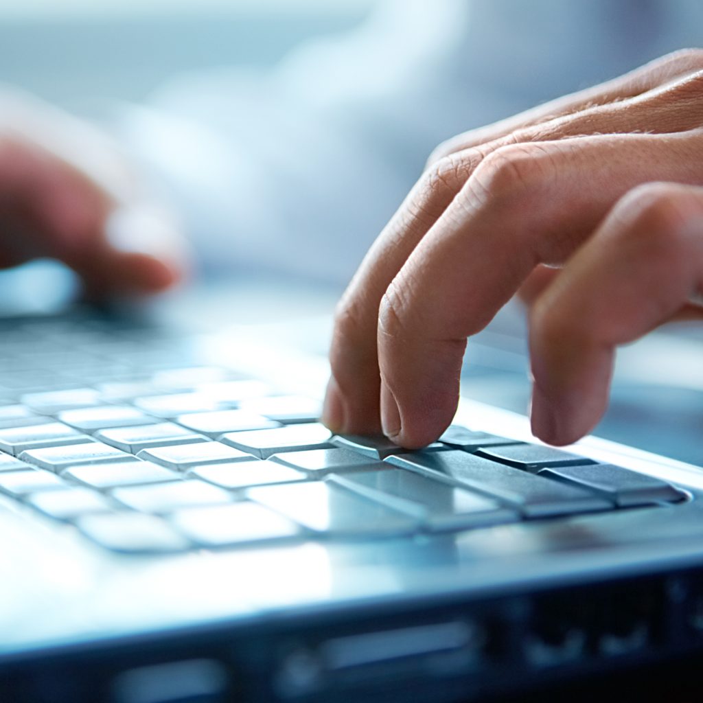 hands typing on a keyboard